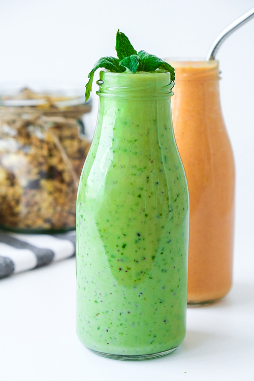 Seasonal Matcha green vegan smoothie with chia seeds and mint pumpkin carrot smoothie drink detox Glass jar granola muesli oatmeal breakfast. Clean eating, weight loss, healthy dieting food concept Fruit vegetable drink fitness