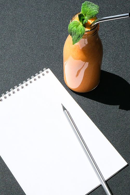 Seasonal pumpkin carrot smoothie drink detox with eco metal drinking straw. Glass bottle of orange smoothie. Paper note copy space. Clean eating, weight loss, healthy dieting food concept. Fruit vegetable drink fitness