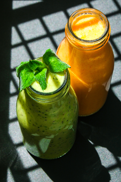 Seasonal Matcha green vegan smoothie with chia seeds and mint pumpkin carrot smoothie drink detox Breakfast. Clean eating, weight loss, healthy dieting food concept Fruit vegetable drink fitness. Trendy shadows