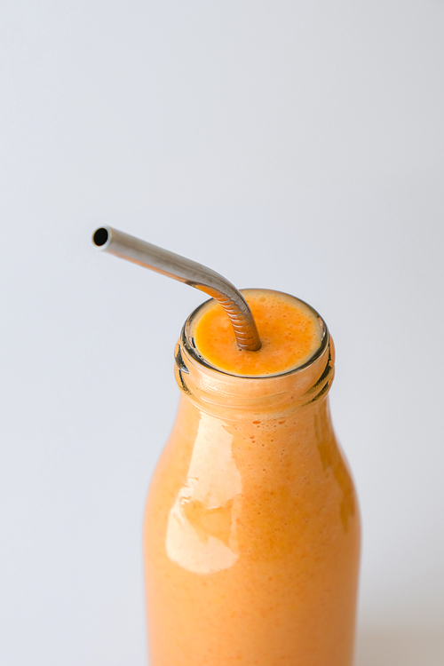 Seasonal pumpkin carrot smoothie drink detox with eco metal drinking straw. Glass bottle of orange smoothie or juice. Clean eating, weight loss, healthy dieting food concept. Fruit vegetable drink fitness