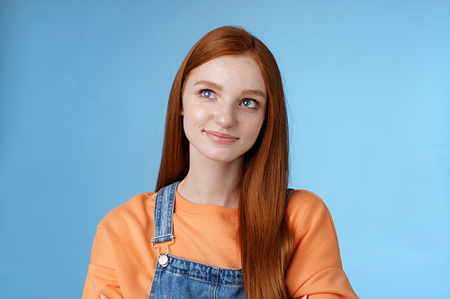 Smart creative pretty redhead female freelancer thoughtfully look upper left corner pondering decision smirking thinking make-up idea standing confident hands crossed chest blue background.