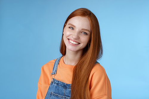 Pleasant sincere happy ginger girl blue eyes tilting head grinning happily laughing stay positive lucky spend time best friends receive praises compliments good job smiling delighted, blue background.