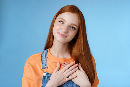 Touched romantic tender cute redhead feminine girl blue eyes tilting head melting heartwarming gesture receive gladly pleasant prest touch heart smiling grateful, feel romance love, blue background.