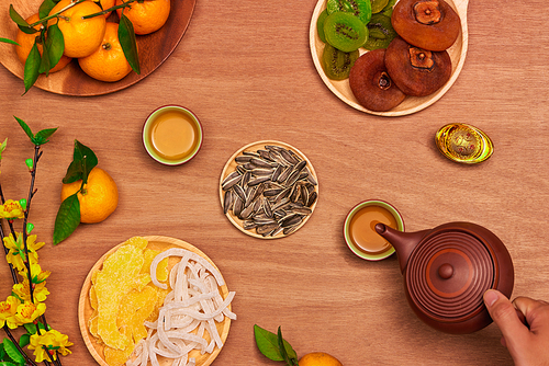 Flat lay Vietnamese new year food and drink on rustic red wooden table top. Text appear in image: Prosperity.