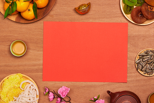 Top view accessories Chinese new year festival decorations.orange,leaf,wood basket,red packet,plum blossom on table wooden background with copy space.