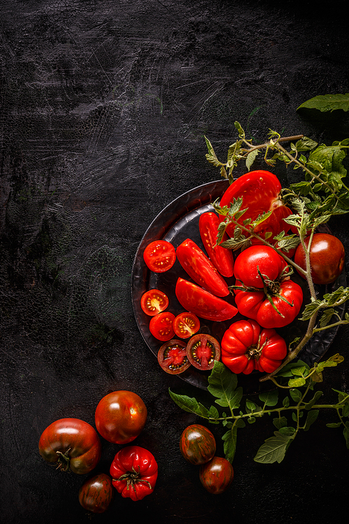 Fresh sliced tomatoes on black background, copy space