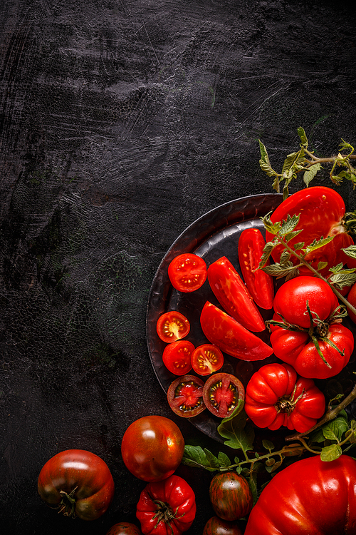 Flat lay of fresh ripe tomatoes on black background