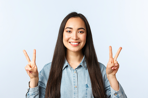 Lifestyle, people emotions and beauty concept. Optimistic attractive female student staying positive, showing v-sign peace gesture and smiling, express happiness and rejoice.