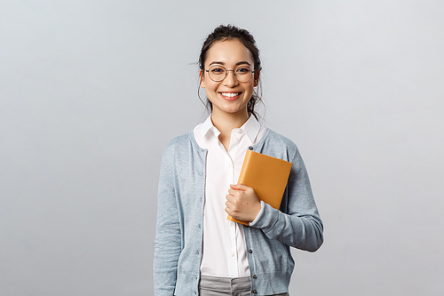 Education, teachers, university and schools concept. Young smiling woman, employer or student in glasses, holding planner, writing down business meetings in notebooks, prepare schedule.