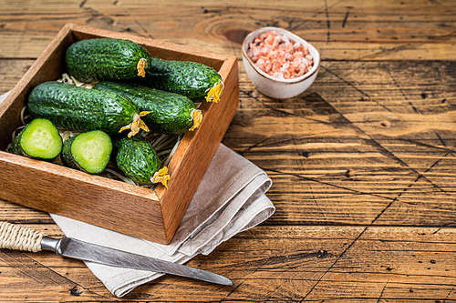 Fresh Green Cucumbers in a wooden box. Wooden background. Top view. Copy space.