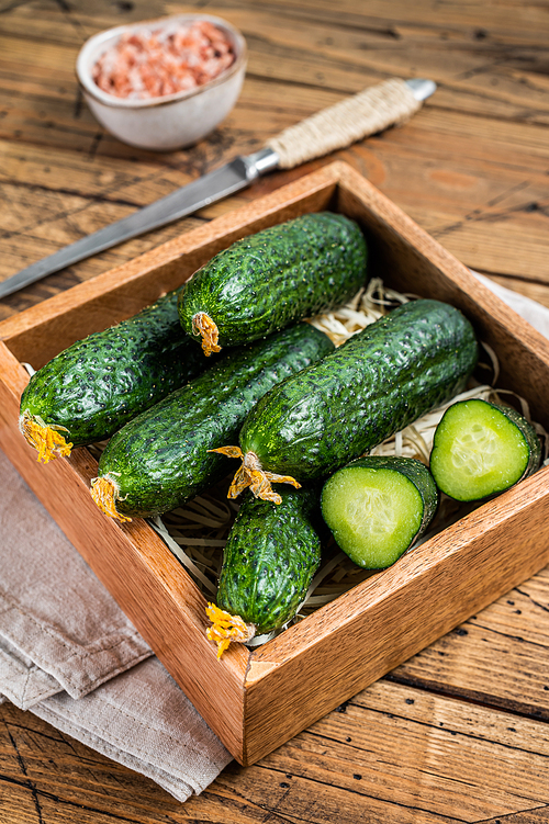 Fresh Green Cucumbers in a wooden box. Wooden background. Top view.