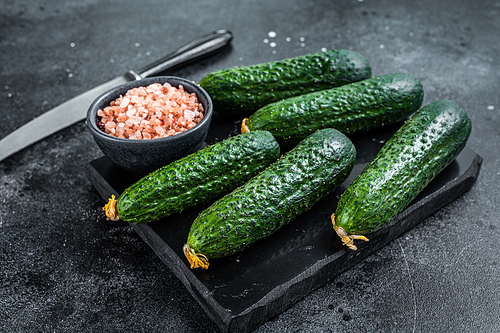 Ripe Green Cucumbers on a marble board. Black background. Top view.
