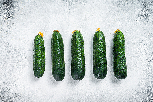 Organic Green Cucumbers on a kitchen table. White background. Top view.