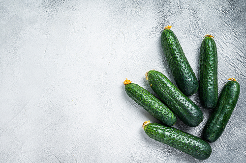 Organic Green Cucumbers on a kitchen table. White background. Top view. Copy space.