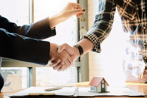 Real estate agent and customers shaking hands together celebrating finished contract after about home insurance and investment loan, handshake and successful deal