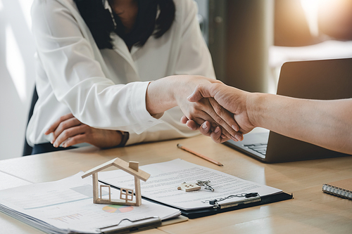 Estate agent and customer shaking hands after finished contract after about home insurance and investment loan