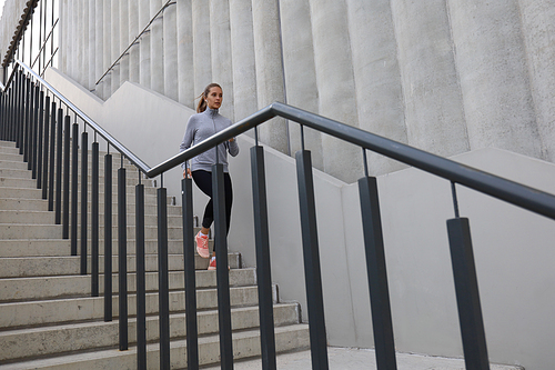 Runner athlete running on stairs. Woman fitness is jogging oudoors.