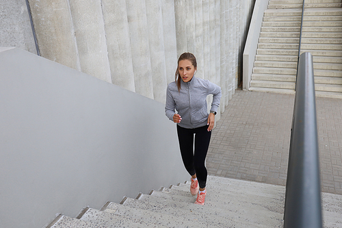 Runner athlete running on stairs. Woman fitness is jogging oudoors.