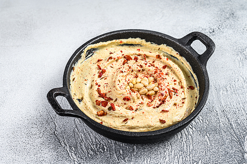 Hummus dip with chickpea in a bowl. White background. Top view.