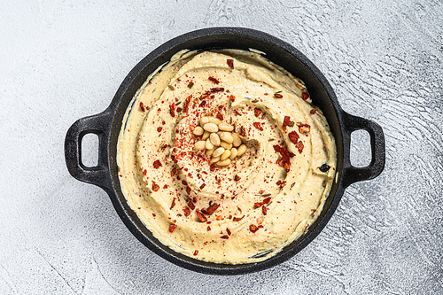 Hummus dip with chickpea in a bowl. White background. Top view.