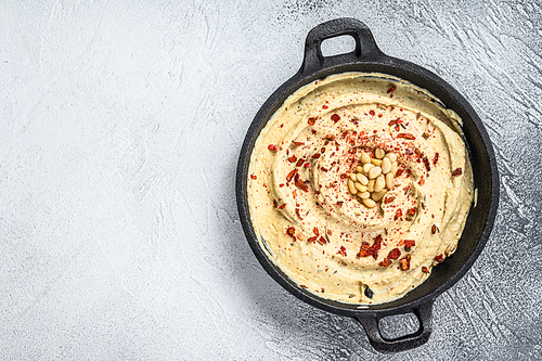 Hummus dip with chickpea in a bowl. White background. Top view. Copy space.