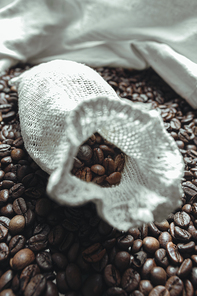 Close up of a coat filled and surrounded by coffee grains