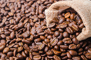 Top view of coffee beans in sack bag on coffee beans background.