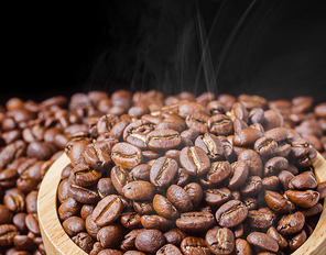 Coffee beans fresh roast with smoke on black background.