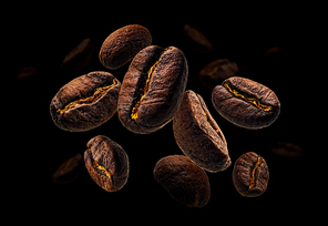 Coffee beans levitate on a black background.