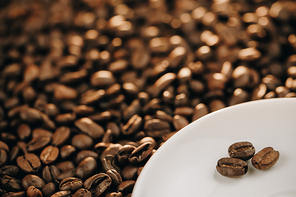 Coffee Beans Background. Three shiny fresh roasted coffee beans with leaves isolated on beans background