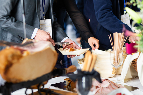 Businesspeople at banquet lunch break at business conference meeting. Assortment of food and drink.