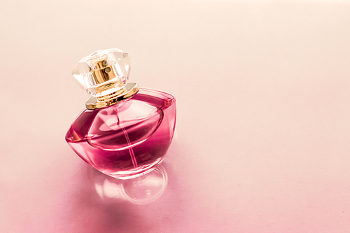 Perfumery, spa and branding concept - Pink perfume bottle on glossy background, sweet floral scent, glamour fragrance and eau de parfum as holiday gift and luxury beauty cosmetics brand design