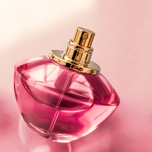 Perfumery, spa and branding concept - Pink perfume bottle on glossy background, sweet floral scent, glamour fragrance and eau de parfum as holiday gift and luxury beauty cosmetics brand design