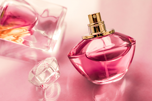 Perfumery, spa and branding concept - Pink perfume bottle on glossy background, sweet floral scent, glamour fragrance and eau de parfum as holiday gift and luxury beauty cosmetics brand design