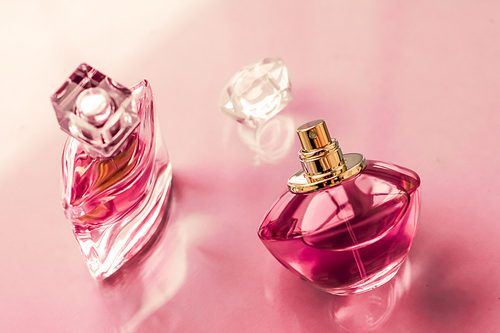 Perfumery, spa and branding concept - Pink perfume bottle on glossy background, sweet floral scent, glamour fragrance and eau de parfum as holiday gift and luxury beauty cosmetics brand design