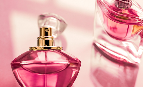 Perfumery, spa and branding concept - Pink perfume bottle on glossy background, sweet floral scent, glamour fragrance and eau de parfum as holiday gift and luxury beauty cosmetics brand design