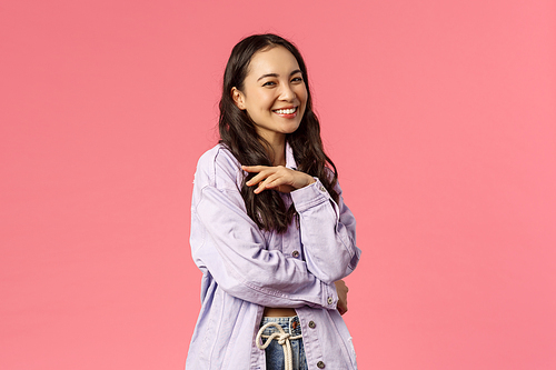 Oh stop it you make me blush. Portrait of silly stylish, good-looking korean girl giggle and talking to someone, hold hand near chest laughing having carefree conversation, pink background.