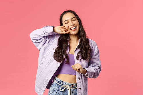 What a beautiful day. Portrait of enthusiastic, happy kawaii girl, smiling enjoying weekends, dancing with closed eyes relaxed pleased face, having fun, have no worries, pink background.