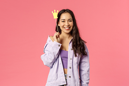 Holidays, lifestyle and people concept. Portrait of charismatic good-looking, stylish asian girl having fun, holding crown stick near head, feeling like little princess, smiling camera.