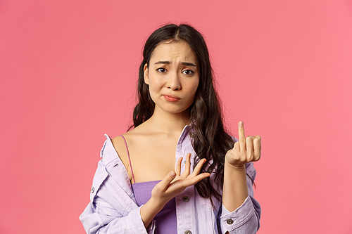 Women, relationship and people concept. Close-up portrait of gloomy complaining asian girl showing finger without ring, smirk and frowning upset, want get married, why boyfriend dont make proposal.