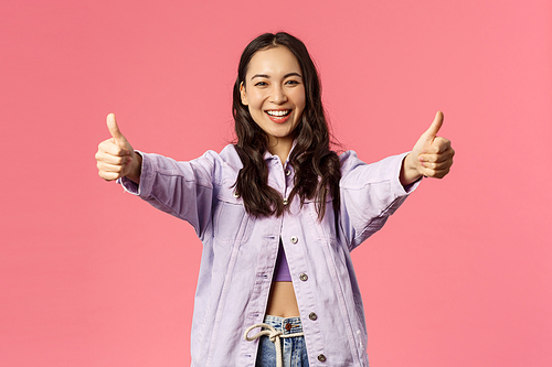Totally agree. Portrait of cheerful young woman in denim jacket approve awesome, super cool idea, show thumbs-up and smiling happy, cheering, rooting or encourage do it, like plan, pink background.