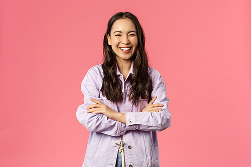 Confident happy young mixed-raise woman, young female student laughing and smiling cheerful, standing over pink background, cross hands over chest assertive, determined pose.