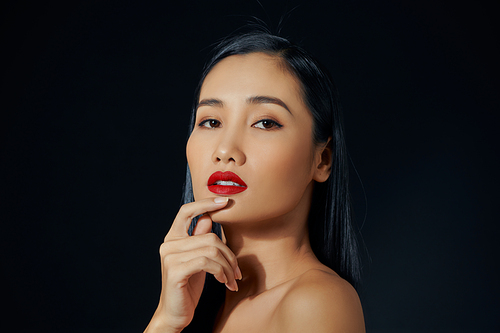 Beautiful young woman with bright lipstick on black background