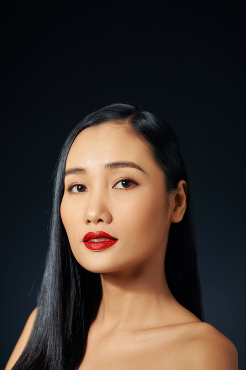 A beautiful tender girl with beautiful long dark hair in black background.