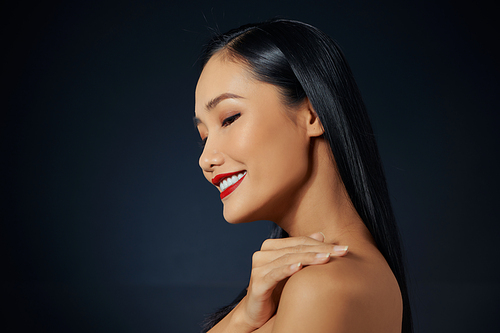 Beautiful young asian woman with long hair on dark gray isolated background