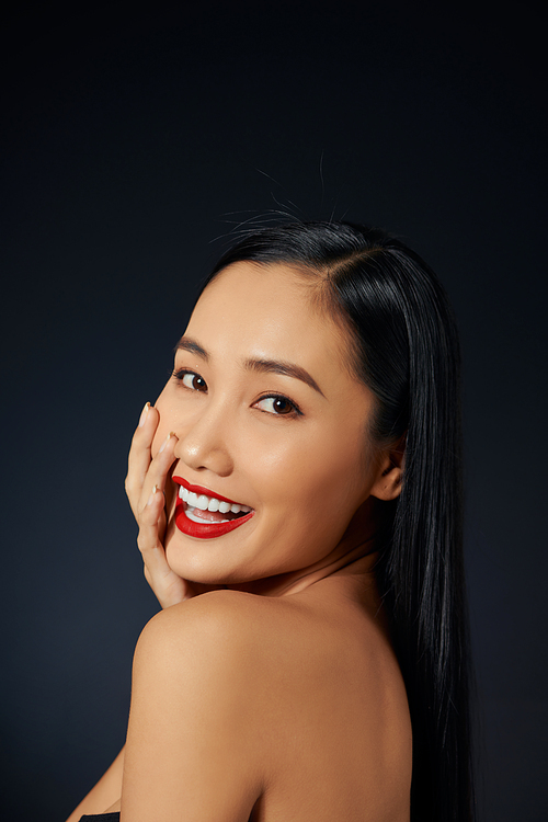 Beautiful young woman with bright lipstick on black background