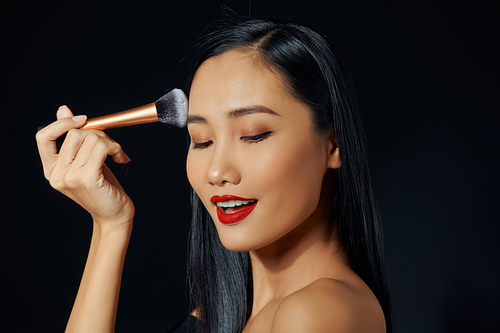 Young asian woman doing make-up