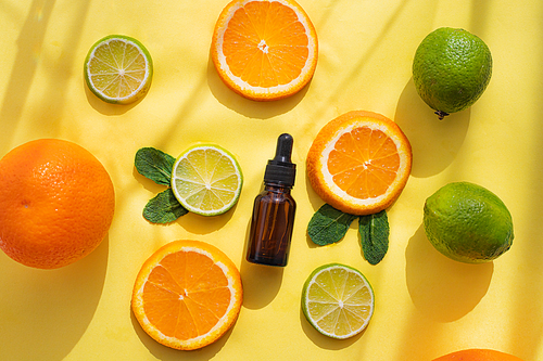 Cosmetic oil and citrus fruits . Cosmetic procedures. Healthy skin. Skin care. Citrus oil. Yellow background.