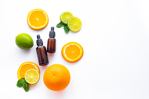 Cosmetic oil and citrus fruits . Cosmetic procedures. Healthy skin. Skin care. Citrus oil. White background. Copy space. Article about care cosmetics