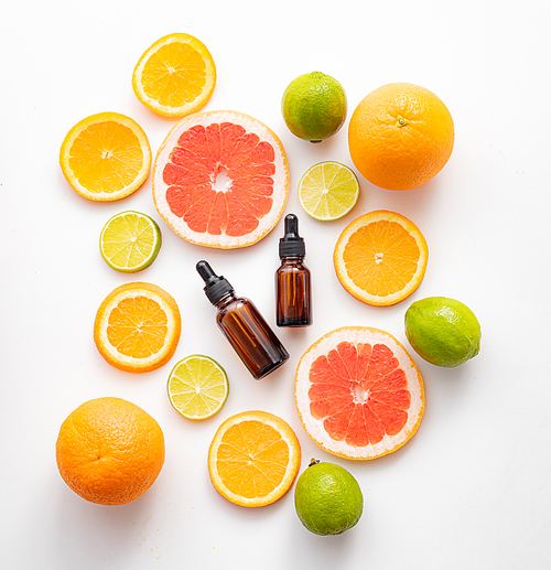 Cosmetic oil and citrus fruits . Cosmetic procedures. Healthy skin. Skin care. Citrus oil. White background. Copy space. Article about care cosmetics